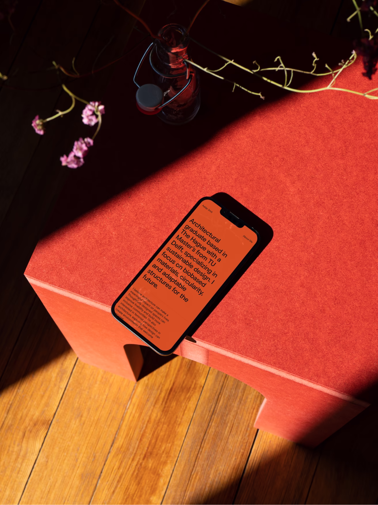 Smartphone on a red table displaying the website of Aaltje Smit.